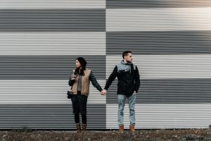 Couple holding hands yet feeling disconnected, with different feelings about the relationship
