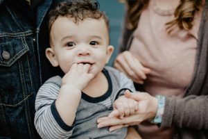 securely attached infant boy with parents nearby